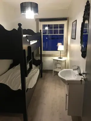 a bedroom with a bunk bed and a sink and a mirror at Kvamseter Lodge in Kvamseter