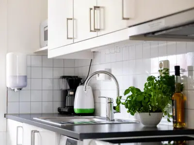 a kitchen with white cabinets and a sink with a plant at Trolltunga Aparthotel in Tysso