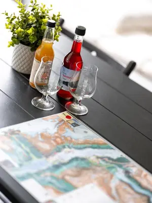 two bottles and glasses on a table with a magazine at Trolltunga Aparthotel in Tysso