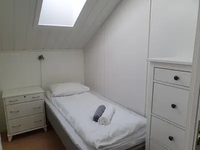 a small bedroom with a bed and a skylight at Lauvøy Feriesenter in Askøy