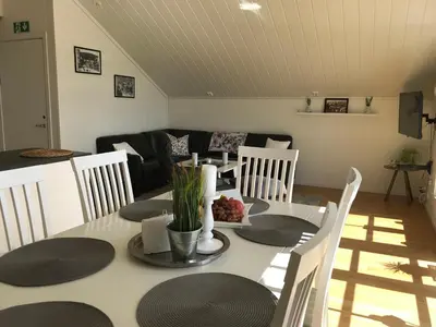 a living room with a table with chairs and a couch at Lauvøy Feriesenter in Askøy