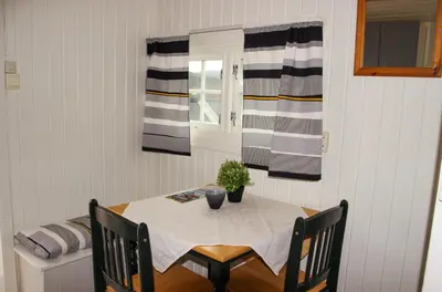 a dining room with a table and a window at Sandli Overnatting in Alvdal