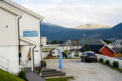 a car parked in a parking lot next to a building at Sandli Overnatting in Alvdal