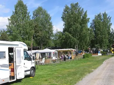 a white truck parked in a field with tents at Steinvik Camping in Moelv