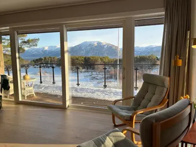 a room with a large window with a view of a mountain at Bosdalhuset in Lavik