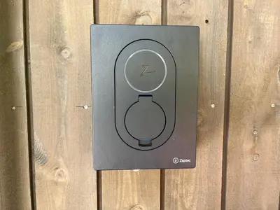 a electrical outlet with a clock on a wooden wall at Bosdalhuset in Lavik