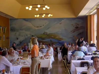 a group of people sitting at tables in a restaurant at Fossli Hotel in Eidfjord
