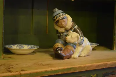 a figurine of a woman holding a teddy bear on a shelf at Fossli Hotel in Eidfjord