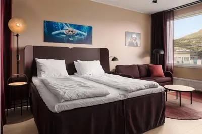 a bedroom with a large bed and a couch at Scandic Sunnfjord Hotel & Spa in Førde