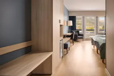 a bedroom with a bed and a desk in a room at Scandic Sunnfjord Hotel & Spa in Førde