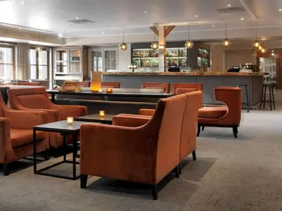 a restaurant with orange chairs and a bar at Scandic Lillehammer Hotel in Lillehammer