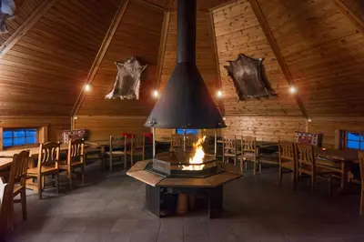 a fireplace in a dining room with tables and chairs at Scandic Lillehammer Hotel in Lillehammer