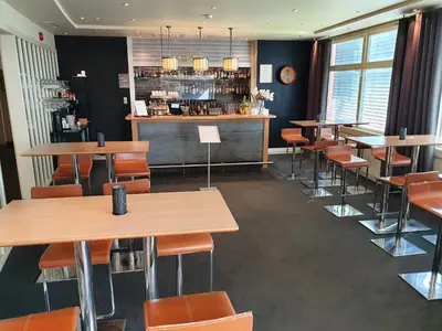 a restaurant with tables and chairs and a bar at Røros Hotell - Bad & Velvære in Røros