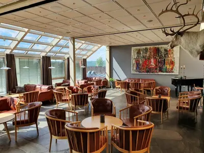 a restaurant with tables and chairs in a room at Røros Hotell - Bad & Velvære in Røros