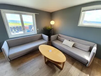 a living room with two couches and a table at Røros Hotell - Bad & Velvære in Røros