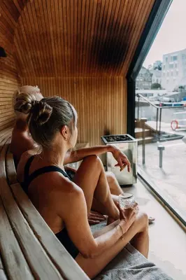 a woman sitting on a bench looking out a window at Hotel Brosundet in Ålesund