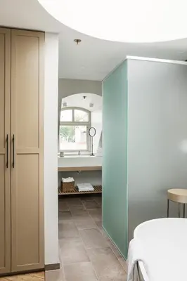 a bedroom with a blue cabinet and a mirror at Hotel Brosundet in Ålesund