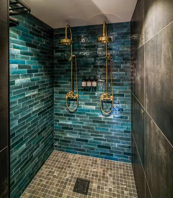 a bathroom with a blue tiled shower with three lights at Villa Vågå - by Classic Norway Hotels in Vågåmo