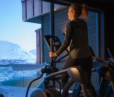 a woman on a treadmill in a gym at Skarsnuten Mountain Resort & SPA in Hemsedal