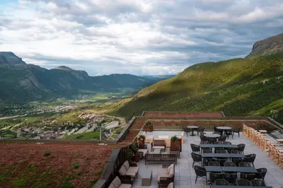 a patio with tables and chairs on top of a mountain at Skarsnuten Mountain Resort & SPA in Hemsedal