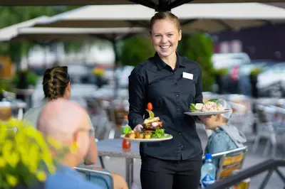 a woman is holding a plate of food at Lampeland Hotel in Lampeland