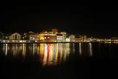 a city at night with lights on the water at Thon Hotel Kristiansund in Kristiansund