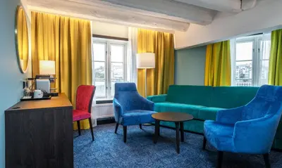 a living room with a green couch and chairs at Thon Hotel Kristiansund in Kristiansund
