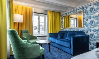 a living room with a blue couch and two chairs at Thon Hotel Kristiansund in Kristiansund