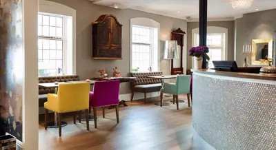 a living room with colorful chairs and a bar at Hotel Park Bergen in Bergen