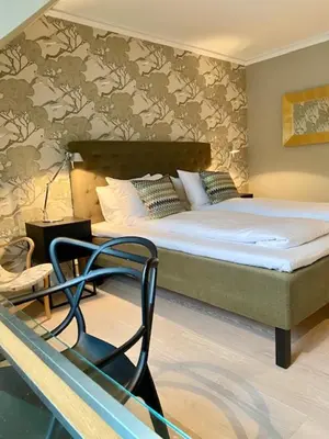 a bedroom with a bed and a chair in it at Hotel Park Bergen in Bergen
