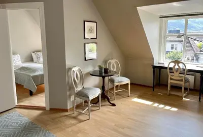 a room with a table and chairs and a bed at Hotel Park Bergen in Bergen