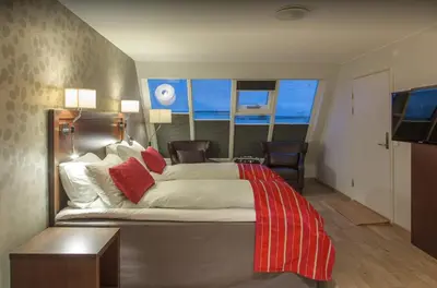 a bedroom with a bed with a red blanket on it at Thon Hotel Victoria Hamar in Hamar