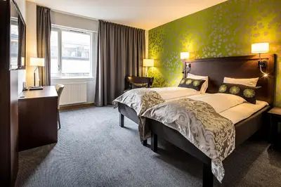 a hotel room with a large bed and a desk at Thon Hotel Victoria Hamar in Hamar
