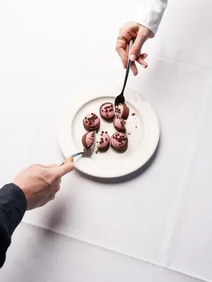 a person eating chocolate donuts on a plate at Vestlia Resort in Geilo