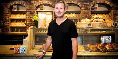 a man is standing in front of a bakery at Highland Lodge in Geilo