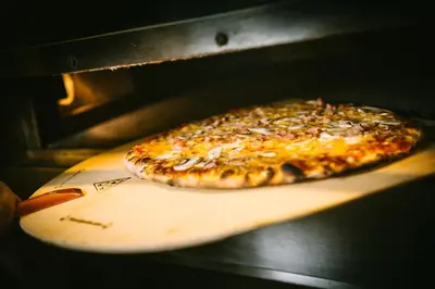 a pizza sitting on a cutting board in an oven at Highland Lodge in Geilo