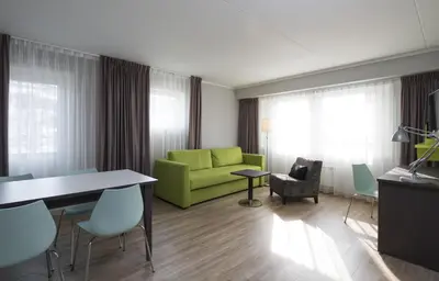 a living room with a green couch and chairs at Thon Hotel Hallingdal in Ål