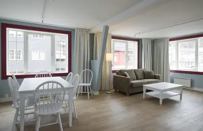a living room with a table and chairs and a couch at Thon Hotel Hallingdal in Ål