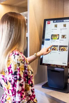 a young girl pointing at a menu on a computer screen at Thon Hotel Hallingdal in Ål
