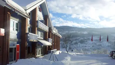 a building with snow on the side of it at Thon Hotel Hallingdal in Ål