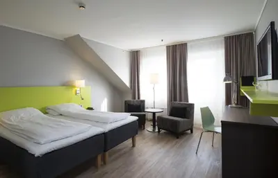 a hotel room with a bed and a chair at Thon Hotel Hallingdal in Ål