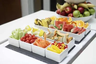 a buffet of fruits and vegetables in white bowls on a table at Thon Hotel Hallingdal in Ål