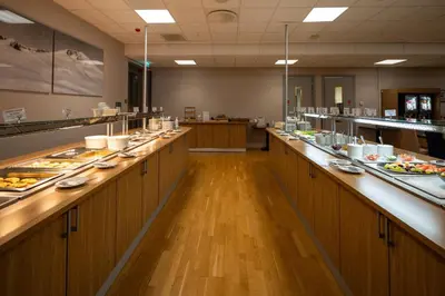 a restaurant with a long buffet line with food at Dombås Hotel in Dombås
