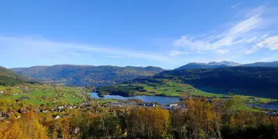 a town in a valley with a lake and mountains at Voss Resort self-service apartments in Skulestadmo