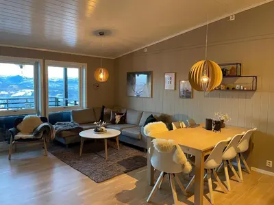 a living room with a couch and a table at Voss Resort self-service apartments in Skulestadmo