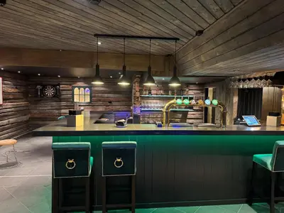 a bar with green bar stools in a restaurant at Skogstad Hotel - Unike Hoteller in Hemsedal