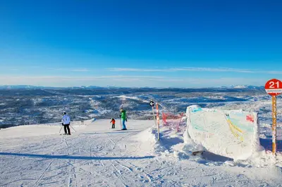 a group of people skiing down a snow covered slope at Thon Hotel Skeikampen in Svingvoll