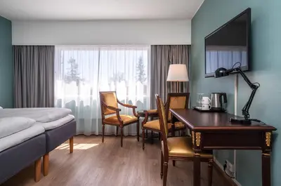 a hotel room with a desk and a bed and a desk and chair at Thon Hotel Skeikampen in Svingvoll