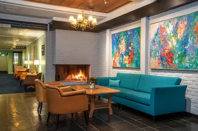 a lobby with a couch and a fireplace at Thon Hotel Skeikampen in Svingvoll