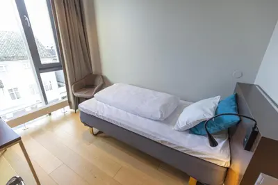 a small bed in a room with a window at Scandic Victoria Florø in Florø